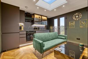 a living room with a green couch in a kitchen at Luxury Studio Retreat in London