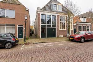 two cars parked in a parking lot in front of a house at Bed & Bike Harbour Hoorn in Hoorn