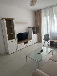 un soggiorno con divano, tavolo e TV di IN APART HOTEL a Bucarest