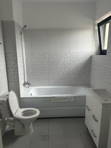 e bagno con vasca, servizi igienici e lavandino. di IN APART HOTEL a Bucarest