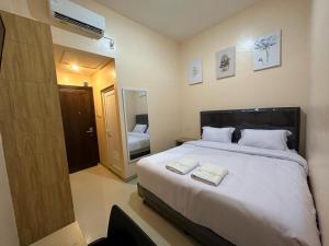 a bedroom with a large bed with two towels on it at GRAND PANDAN HOTEL in Halangan