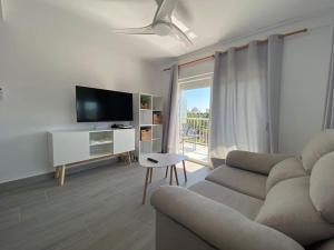 een woonkamer met een bank en een tv bij Apartamento vacacional en Denia in Denia