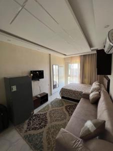 um quarto de hotel com um sofá e uma cama em zooz home vacation em El Alamein