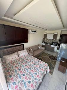 um quarto com uma cama e um sofá em zooz home vacation em El Alamein