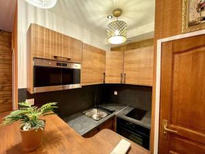 een keuken met houten kasten en een tafel met een plant bij Appartement chalet n°5 in Noisy-le-Sec