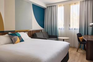 a hotel room with a bed and a desk at Holiday Inn - Marseille Airport, an IHG Hotel in Vitrolles