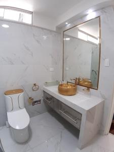a bathroom with a sink and a toilet and a mirror at APARTAMENTO LINDO - A 2 Cuadras de la Plaza de Armas y del Palacio de Gobierno in Lima