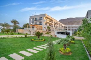 un gran edificio con un patio con palmeras en Al Masa Hotel El Sokhna en Ain Sokhna