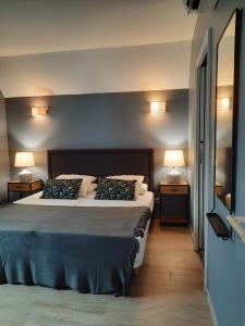 sypialnia z dużym łóżkiem z dwoma lampami po obu stronach w obiekcie Appartement 50m du centre historique w mieście Sarlat-la-Canéda +11 zdjęć