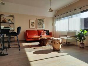salon z czerwoną kanapą i stołem w obiekcie Appartement 50m du centre historique w mieście Sarlat-la-Canéda