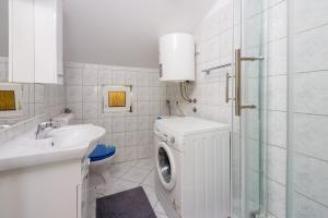a bathroom with a washing machine and a sink at Apartment Davor in Dramalj