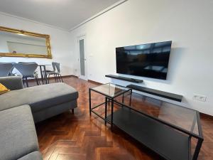 sala de estar con sofá y TV de pantalla plana en Oktheway Big Coruña, en A Coruña