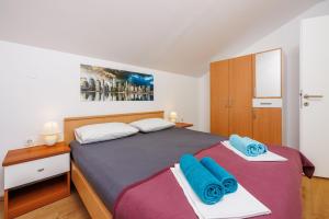a bedroom with a large bed with blue towels at Apartment Davor in Dramalj