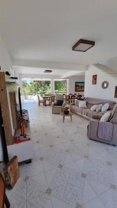 ein großes Wohnzimmer mit Sofas und einem Tisch in der Unterkunft Casa da Barbie na praia de Carapibus PB in Conde