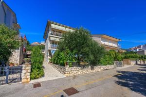 a building with a stone wall next to a street at Apartments Antonio in Crikvenica