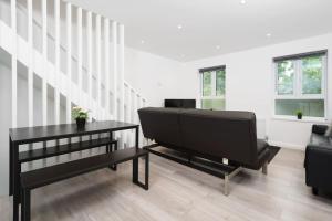 een woonkamer met een zwarte tafel en een bank bij Lovely 3 Bed Flat in a Great Location in London in Londen