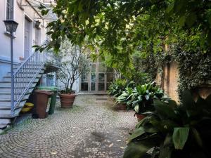 un patio con macetas y escaleras en un edificio en Prada District Milan Apartment, en Milán