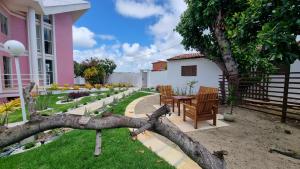 a tree branch laying on the ground next to a house at Casa da Barbie na praia de Carapibus PB in Conde