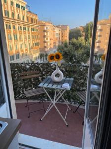 - une table avec un vase de fleurs sur le balcon dans l'établissement Casa Girasole, à Rome