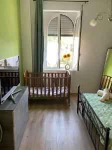 - une chambre avec 2 lits bébé et une fenêtre dans l'établissement Casa Girasole, à Rome