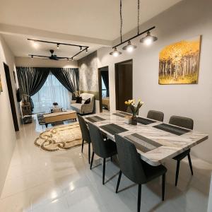 a dining room and living room with a table and chairs at D'Elegant Suite - Emerald Avenue in Cameron Highlands