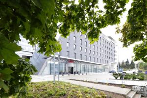 - un grand bâtiment blanc avec des fenêtres en verre dans l'établissement Hampton By Hilton Olsztyn, à Olsztyn