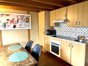 a kitchen with a wooden table and a table and chairs at Le chalet bucolique au bord de l'eau in Olivet