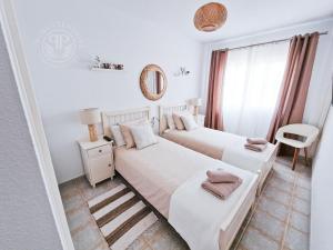 2 camas en una habitación blanca con ventana en 2 Wings Tenerife - Apartment Chayofa en Chayofa