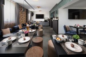 um restaurante com mesas e cadeiras com comida em We rooms Hotel em Karben