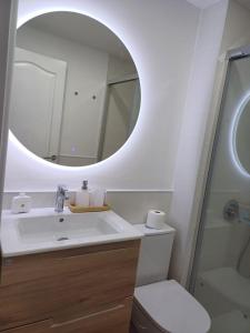 een badkamer met een wastafel en een spiegel bij OMBÚLAFUENTE in Puerto de Mogán