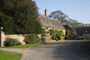 an empty road in a village with houses at Alpaca Lodge in Burford