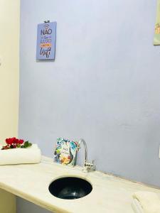 a bathroom counter with a sink and a sign on the wall at SITIO RECANTO DOS PASSAROS in Itacaré
