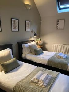 エクセターにあるBlue Ball Inn, Sandygate, Exeterのベッドルームにタオル付きのベッド2台が備わります。