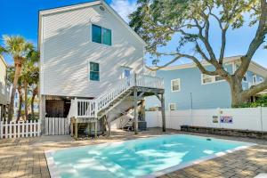 a house with a swimming pool in front of a house at Surfside Beach Oasis with Private Pool and Gas Grill! in Myrtle Beach