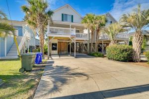 a house with palm trees and a sidewalk at Surfside Beach Oasis with Private Pool and Gas Grill! in Myrtle Beach