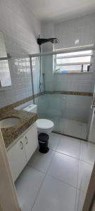 La salle de bains est pourvue de toilettes, d'un lavabo et d'une douche. dans l'établissement Apartamento 3/4 ótima localização, à Aracaju