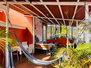 a room with a hammock in a restaurant at Casa de Lis Hotel & Tourist Info Centre in Turrialba