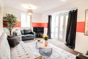 a living room with a couch and a table at Modern 2BR Apartment in the heart of East London, Fast Internet & Close To Shops in London