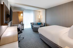 a hotel room with a bed and a chair at Courtyard by Marriott Atlanta Vinings/Galleria in Atlanta