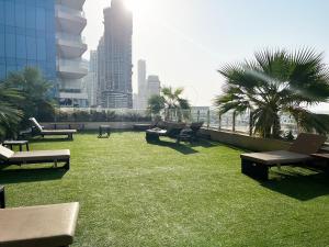 a rooftop patio with grass and benches on a building at SKY High Stays in Dubai