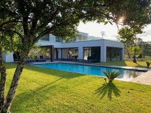 een huis met een zwembad in een tuin bij La Villa Blanche in Saint-Cézaire-sur-Siagne