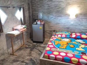 a bedroom with a mickey bed and a small refrigerator at โรงแรมบ้านสวนบางภูมิ in Ban Pa Kathum (1)