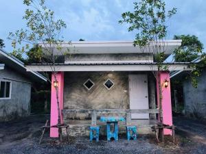 a house with two chairs and a table in front of it at โรงแรมบ้านสวนบางภูมิ in Ban Pa Kathum (1)