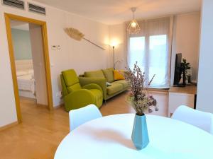 uma sala de estar com um sofá verde e uma mesa em La Terraza de Predicadores by Alogest em Zaragoza