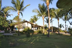 um grupo de palmeiras em frente a uma casa em Fazenda Pranchão em Prado