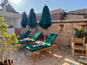 a couple of chairs and umbrellas on a patio at Riad Tizwa Marrakech in Marrakesh