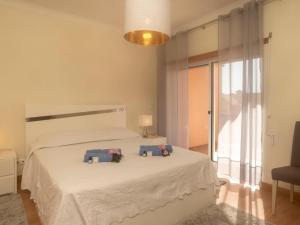 a bedroom with a white bed with two pillows on it at Holiday Home O segredo de Sesimbra by Interhome in Sesimbra +12 photos