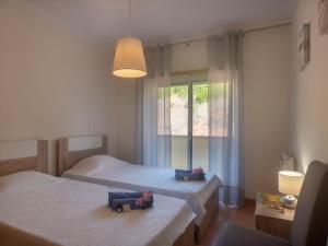 a bedroom with two twin beds and a window at Holiday Home O segredo de Sesimbra by Interhome in Sesimbra