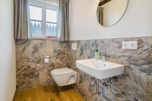 a bathroom with a sink and a toilet and a mirror at Landluft Ferien - Wohnung Abendrot in Heiligenberg +27 photos