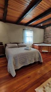 uma cama grande num quarto com piso em madeira em Cabana Casa Enxaimel em Picada Cafe